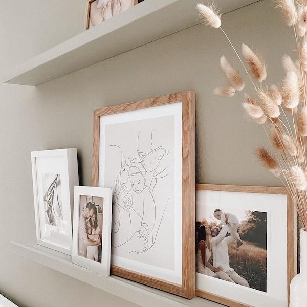 Muro de fotos familiares, incluyendo un dibujo Line Art de una familia joven, publicación de Instagram de @adriane